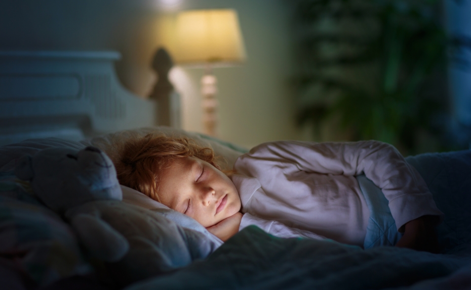 Kind liegt im Bett und schläft. 